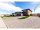 Long brick driveway leading to a three-car garage, complemented by lush, artificial turf landscaping at 1983 E Sarona Ct, San Tan Valley, AZ 85143