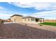 Rear exterior view of beige house with an artificial lawn, and gravel landscaping at 1983 E Sarona Ct, San Tan Valley, AZ 85143