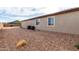 Beige house exterior with two windows, surrounded by gravel and showcasing two AC units at 1983 E Sarona Ct, San Tan Valley, AZ 85143