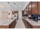 Spacious kitchen featuring a large island, granite countertops, and dark wood cabinetry at 1983 E Sarona Ct, San Tan Valley, AZ 85143