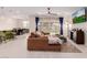 Open-concept living room featuring wood tile floors, ceiling fan, and comfortable brown sectional sofa at 1983 E Sarona Ct, San Tan Valley, AZ 85143