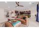 Open-concept living room featuring wood tile floors, ceiling fan, and comfortable brown sectional sofa at 1983 E Sarona Ct, San Tan Valley, AZ 85143