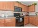 Well-equipped kitchen with stove, microwave, and wood cabinets at 20876 N Canyon Whisper Dr, Surprise, AZ 85387