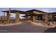 Covered entrance with stone pillars and landscaped driveway leading to a luxurious desert lodge at 23491 N 125Th Pl, Scottsdale, AZ 85255