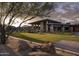 Expansive building exterior with lush lawn, stone columns, and outdoor seating under a cloudy sky at 23491 N 125Th Pl, Scottsdale, AZ 85255