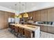 Modern kitchen with wood cabinets, large island, and gold pendant lights at 23491 N 125Th Pl, Scottsdale, AZ 85255