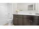 Bathroom featuring dark cabinets, a shower-tub combo, and floral decor at 24134 N Cotton Cir, Florence, AZ 85132