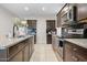 Open kitchen with dark cabinets, granite counters, and stainless steel appliances at 24134 N Cotton Cir, Florence, AZ 85132