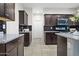 A well-lit kitchen with dark cabinetry, stainless steel appliances, and granite countertops at 24134 N Cotton Cir, Florence, AZ 85132