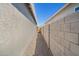 Narrow side yard with gravel and block wall leading to a gate at 24134 N Cotton Cir, Florence, AZ 85132