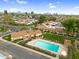 Aerial view of a community with pool, surrounded by lush greenery, homes, and mature palm trees at 2442 N 22Nd Ave, Phoenix, AZ 85009