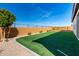 This backyard features artificial turf, a privacy wall, and landscaping at 25948 W Sands Dr, Buckeye, AZ 85396