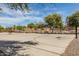 Community basketball court surrounded by trees, providing a great outdoor space for sports and recreation at 25948 W Sands Dr, Buckeye, AZ 85396