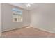 Sunlit bedroom featuring neutral carpet and paint, with a view to the backyard at 25948 W Sands Dr, Buckeye, AZ 85396