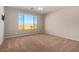 This bedroom features a ceiling fan and a large window overlooking the exterior at 25948 W Sands Dr, Buckeye, AZ 85396