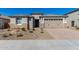 Attractive single-story home featuring a stone facade, desert landscaping, and a two-car garage at 25948 W Sands Dr, Buckeye, AZ 85396