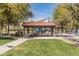 Community playground with picnic benches and shade canopies amongst mature trees at 25948 W Sands Dr, Buckeye, AZ 85396