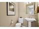 Clean powder room with pedestal sink, toilet and neutral color scheme at 27379 N Makena Pl, Peoria, AZ 85383