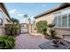 Private courtyard with brick pavers, wrought iron gate, and lush greenery at 27379 N Makena Pl, Peoria, AZ 85383