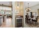 Elegant dining area with wine cooler and views to kitchen and living room at 27379 N Makena Pl, Peoria, AZ 85383