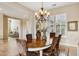 Bright dining room with oval table, chandelier, and views to living room at 27379 N Makena Pl, Peoria, AZ 85383