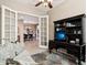 Home office with French doors opening to dining room, built-in shelving, and comfortable seating at 27379 N Makena Pl, Peoria, AZ 85383