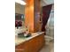 Bathroom with granite countertop, dark sink, and wooden cabinetry at 28492 N 95Th Pl, Scottsdale, AZ 85262