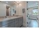 Bright bathroom featuring a double vanity with granite counters and framed mirrors at 2967 E Boot Track Trl, Gilbert, AZ 85296