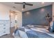 Bedroom featuring a decorative blue accent wall, ceiling fan, and a comfortable bed at 2967 E Boot Track Trl, Gilbert, AZ 85296