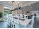 A bright dining room with modern light fixture adjoins a chef's kitchen with stainless appliances and a spacious living room at 2967 E Boot Track Trl, Gilbert, AZ 85296