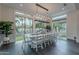 Bright dining area with large windows looking into the landscaped backyard and showcasing a modern chandelier at 2967 E Boot Track Trl, Gilbert, AZ 85296