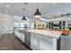 An oversized island with a stainless steel sink is the focal point in this bright kitchen with modern appliances at 2967 E Boot Track Trl, Gilbert, AZ 85296