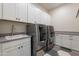 Spacious laundry room with white cabinets, gray countertops, sink, and modern washer and dryer at 2967 E Boot Track Trl, Gilbert, AZ 85296