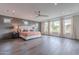 Large main bedroom featuring wood floors, ceiling fan, and large windows at 2967 E Boot Track Trl, Gilbert, AZ 85296