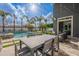 Outdoor poolside dining area with stylish patio furniture and a view of the sparkling pool and palms at 2967 E Boot Track Trl, Gilbert, AZ 85296