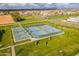 Aerial view of community tennis courts surrounded by lush green landscaping and trees at 2967 E Boot Track Trl, Gilbert, AZ 85296