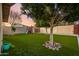 Large backyard with green grass, a play structure, and trees with rock accents at 302 E Coral Gables Dr, Phoenix, AZ 85022