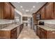 Long, well-lit kitchen with stainless steel appliances, granite countertops, and dark cabinetry at 302 E Coral Gables Dr, Phoenix, AZ 85022