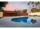 Backyard pool with a privacy fence, pergola, palm trees, and lush landscaping at 302 E Coral Gables Dr, Phoenix, AZ 85022