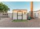 Tan and gray storage shed in backyard with small artificial turf area at 410 N 56Th Pl, Mesa, AZ 85205