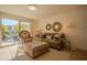 Bright living room featuring a comfortable olive sofa, patterned ottoman, and sliding door access to an outdoor patio at 4354 N 82Nd St # 137, Scottsdale, AZ 85251