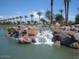 Scenic community waterfall feature with lush landscaping and picturesque rock formations under a clear blue sky at 476 E Atlantic Dr, Casa Grande, AZ 85122