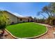 Backyard area with artificial turf, mature landscaping, and brick edging at 50031 N 27Th Ave, New River, AZ 85087