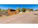 View of the house and storage shed from the gravel driveway with native landscaping at 50031 N 27Th Ave, New River, AZ 85087