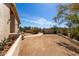 Charming stucco home exterior with gravel driveway and lush desert landscaping at 50031 N 27Th Ave, New River, AZ 85087