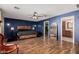 Spacious main bedroom features dark blue accent wall, modern ceiling fan, and hard wood floors at 50031 N 27Th Ave, New River, AZ 85087