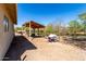 Covered storage area with a wooden structure, fence, and a wheelbarrow at 50031 N 27Th Ave, New River, AZ 85087