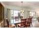 Bright dining area with glass table and wood chairs, overlooking a view through large windows at 5807 E Leonora St, Mesa, AZ 85215