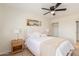 Bedroom with neutral tones, ceiling fan, white bedding, and art piece that creates a calm space at 7444 N 43Rd Ln, Glendale, AZ 85301