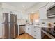 Beautiful kitchen featuring stainless steel appliances, white cabinetry, and hardwood floors at 7444 N 43Rd Ln, Glendale, AZ 85301